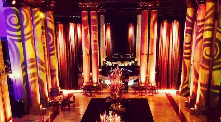 Sala de fiestas con escenario, cortinas rojas e iluminación para una fiesta de cumpleaños en Granada